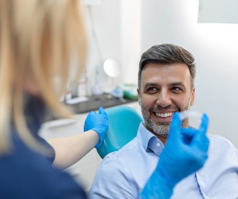 Dentist checking on patient’s Invisalign progress 