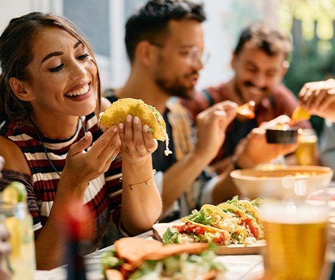 Woman smiling while eating lunch with friends at restaurant