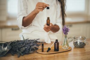 Woman in white blouse preparing to use lavender essential oil